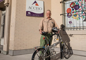 John Macmillan standing in front of the Acesso branch with his bike