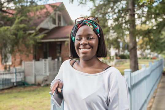 Tynice, DC Credit Union member, standing in front of her home