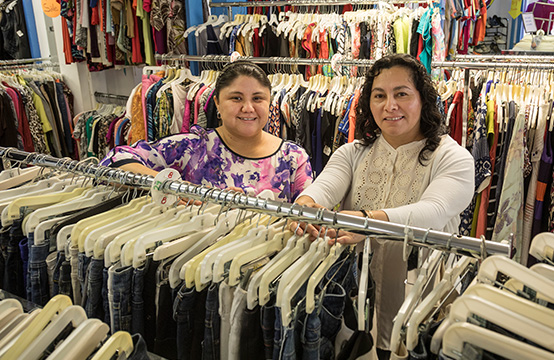 Two women standing in a clothing store