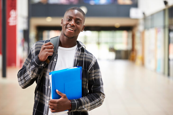 Portrait Of Male Student Standing In College Building